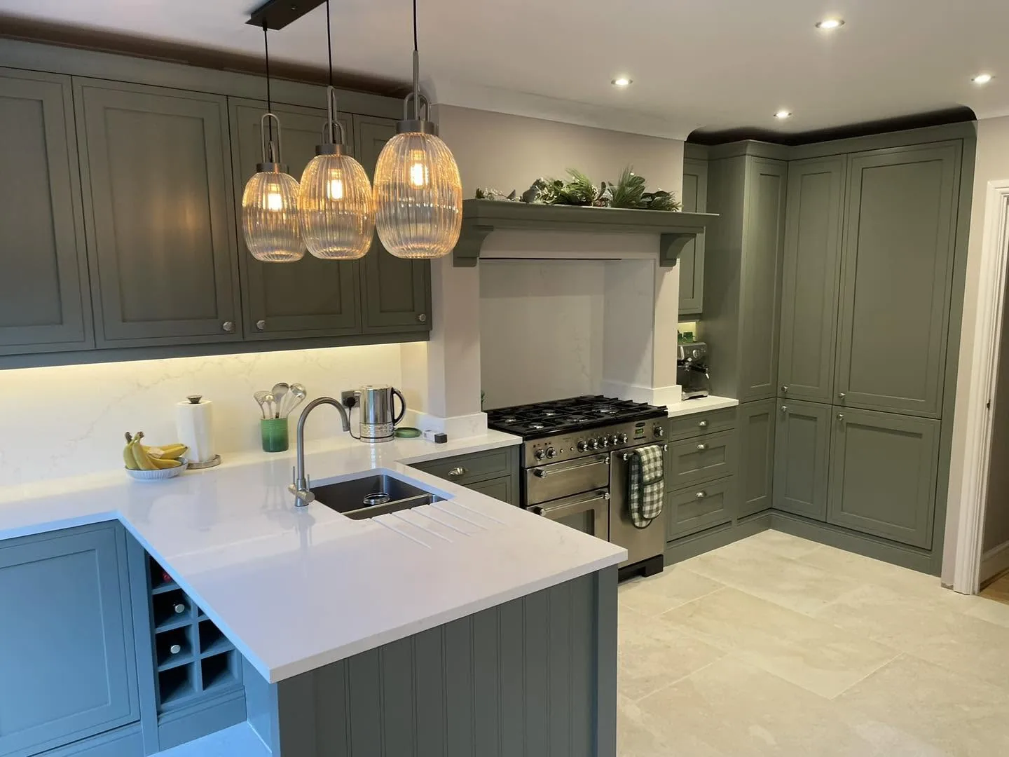 Dark green shaker kitchen with a range cooker and pendant lights